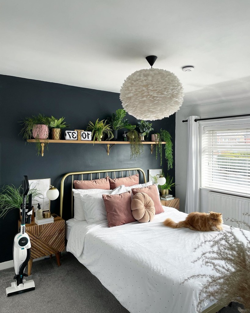 pink and grey bedroom with dark walls and brass bed frames
