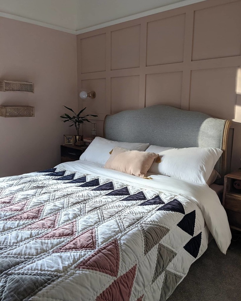 pink and grey bedroom with patchwork quilt and panelled walls