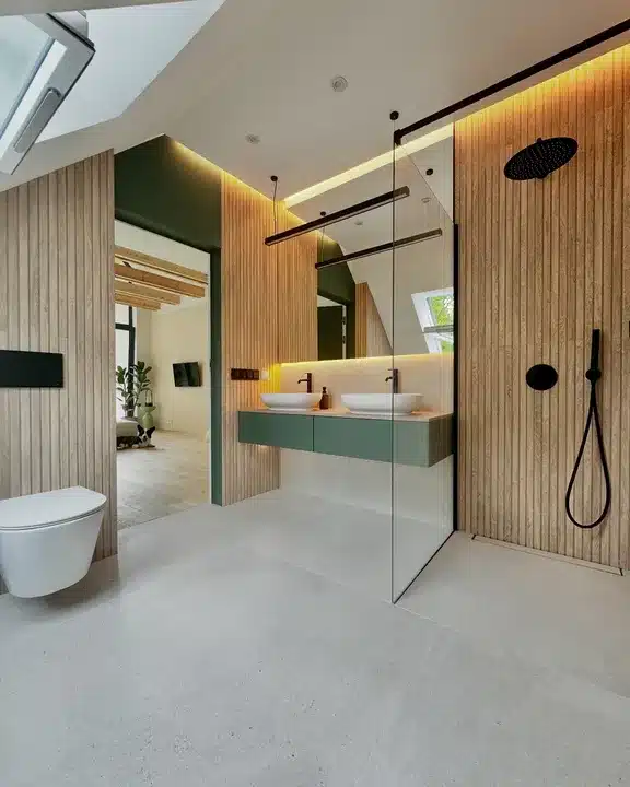 Loft bathroom with slatted wood-effect walls, green double vanity and LED lighting from the Porcelanosa sale
