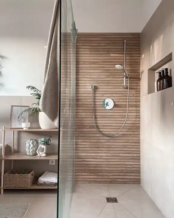 Wood-effect tiled shower wall with a chrome shower set and recessed shelf