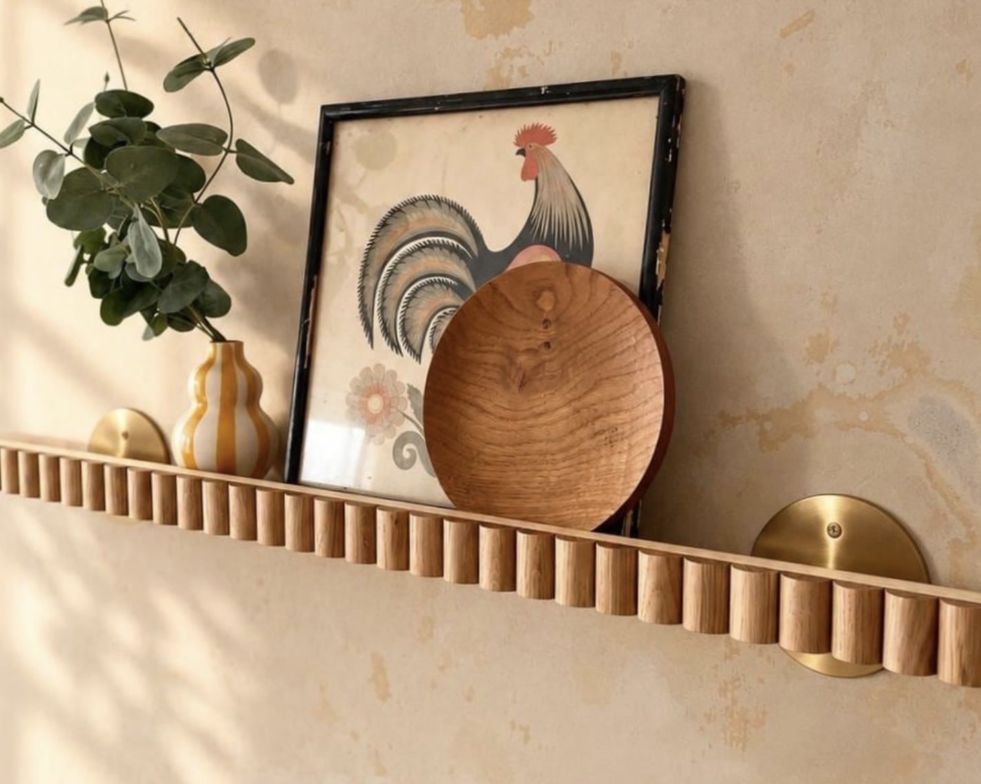 Scalloped oak art deco floating shelf with a vase, round wooden board and elephant ornament, kitchen floating shelves