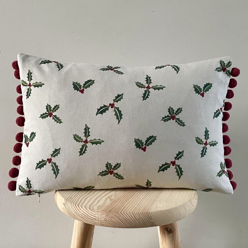 Stone holly and berry Christmas cushion with burgundy pompom trim