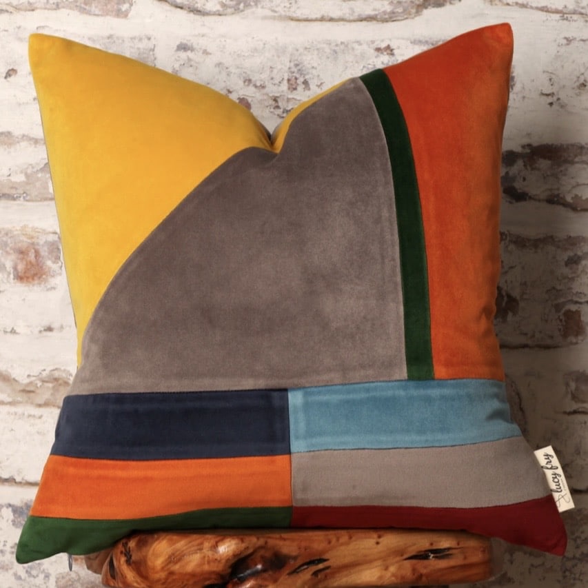 Bauhaus-style velvet cushion with orange, mustard, teal, green and taupe geometric panels